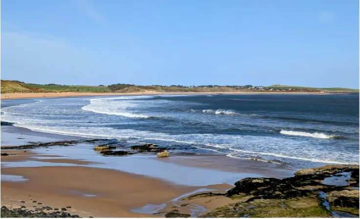 Waves rolling onto the sandy shore at Embleton Beach